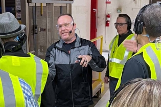 People listening to a machine shop tour.