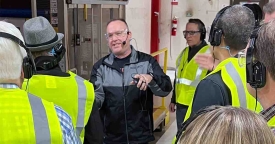 People listening to a machine shop tour.