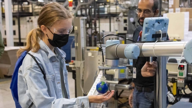 Student at Suncast corp with a small globe in her hand.